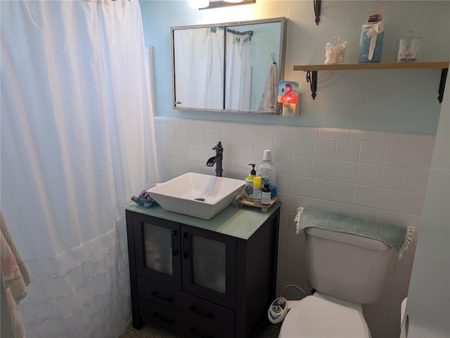 bathroom with tile walls, toilet, and vanity