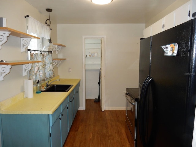 kitchen with a sink, white cabinets, freestanding refrigerator, open shelves, and decorative light fixtures