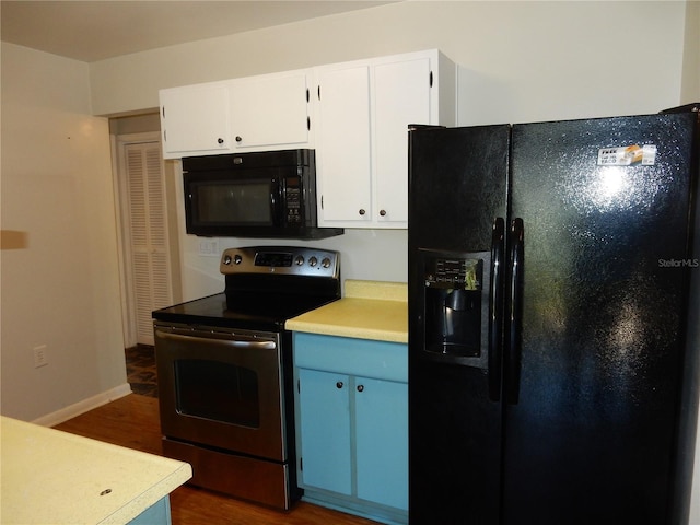 kitchen featuring baseboards, dark wood finished floors, light countertops, black appliances, and white cabinetry