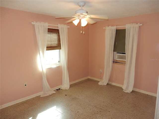 unfurnished bedroom with ceiling fan, speckled floor, cooling unit, and baseboards