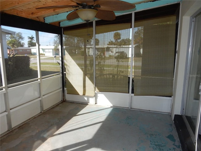 unfurnished sunroom featuring a ceiling fan