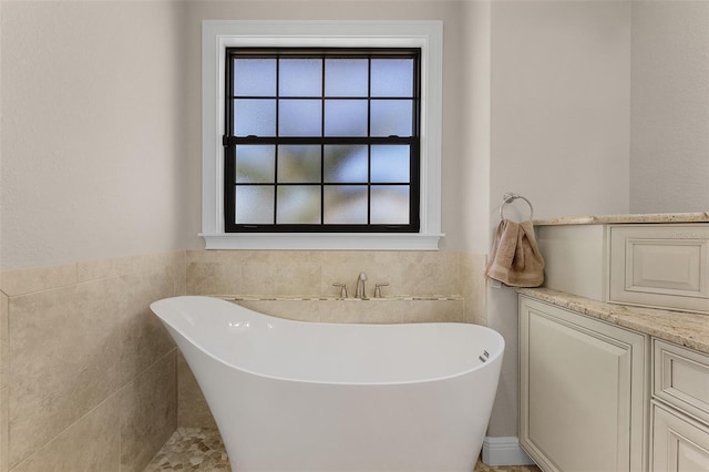 bathroom with tile walls, a bath, and plenty of natural light