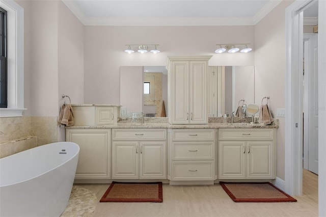 bathroom featuring a washtub, ornamental molding, hardwood / wood-style flooring, and vanity