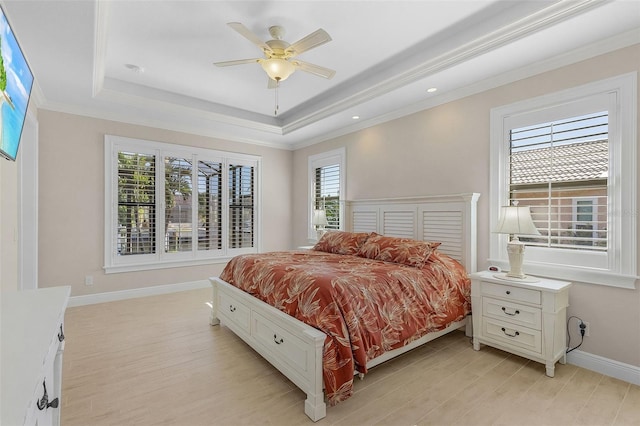 bedroom with ceiling fan, crown molding, light wood-type flooring, and a raised ceiling