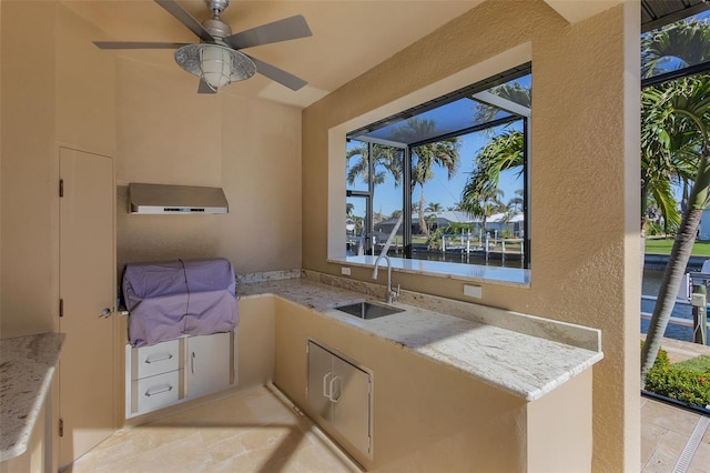 view of patio featuring sink, an outdoor kitchen, and a water view