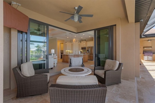 view of patio / terrace featuring ceiling fan and a fire pit