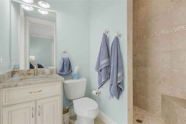 bathroom with toilet, a tile shower, ornamental molding, and vanity