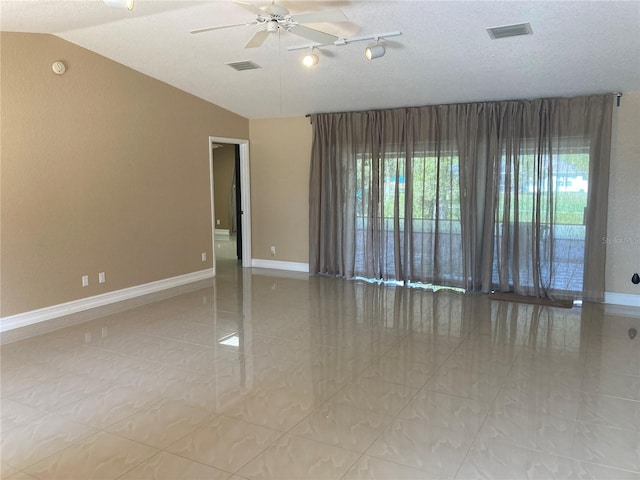 spare room featuring a textured ceiling, ceiling fan, and lofted ceiling