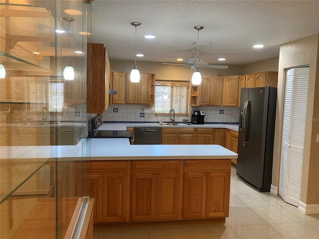 kitchen featuring pendant lighting, black appliances, decorative backsplash, sink, and ceiling fan