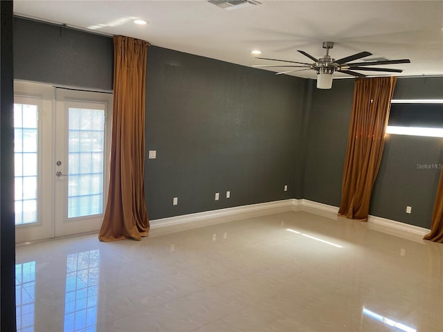 empty room featuring ceiling fan, light tile patterned flooring, and french doors