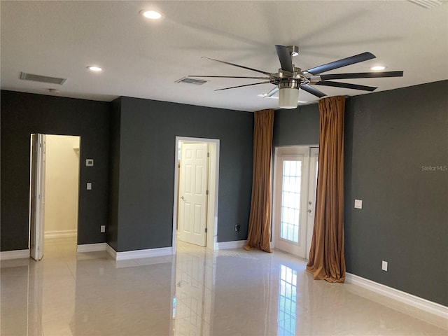 tiled empty room featuring ceiling fan