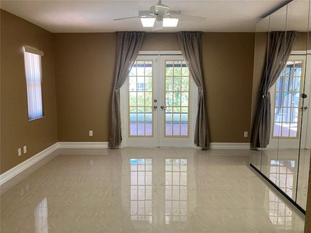 empty room with ceiling fan, light tile patterned floors, and french doors