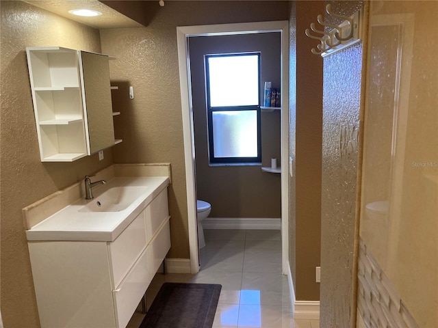 bathroom featuring toilet, vanity, and tile patterned flooring