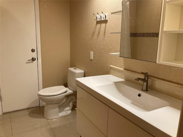 bathroom featuring toilet, vanity, and tile patterned floors