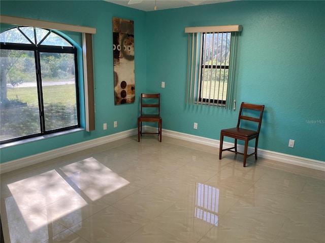 sitting room with ceiling fan, a healthy amount of sunlight, and light tile patterned floors