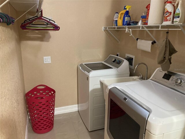 washroom with independent washer and dryer and light tile patterned flooring