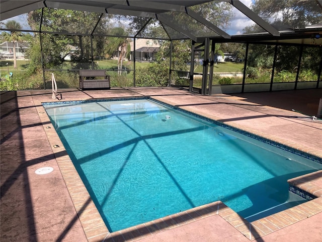 view of swimming pool featuring glass enclosure and a patio