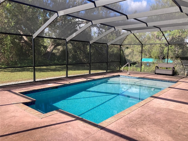 view of pool with glass enclosure and a patio