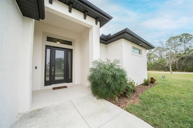 view of exterior entry with a lawn