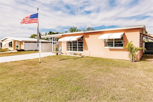 view of front of house with a front lawn and a carport