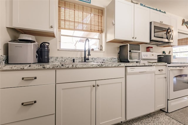 kitchen featuring white cabinetry, sink, and white appliances