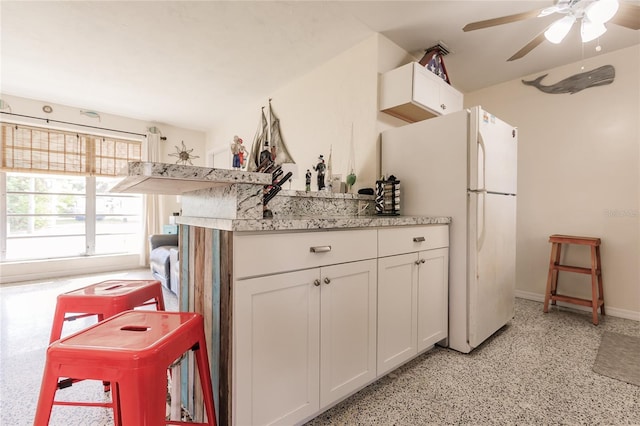 kitchen featuring ceiling fan, white cabinets, and white refrigerator