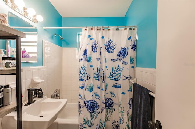 bathroom with sink, tile walls, and shower / bath combination with curtain