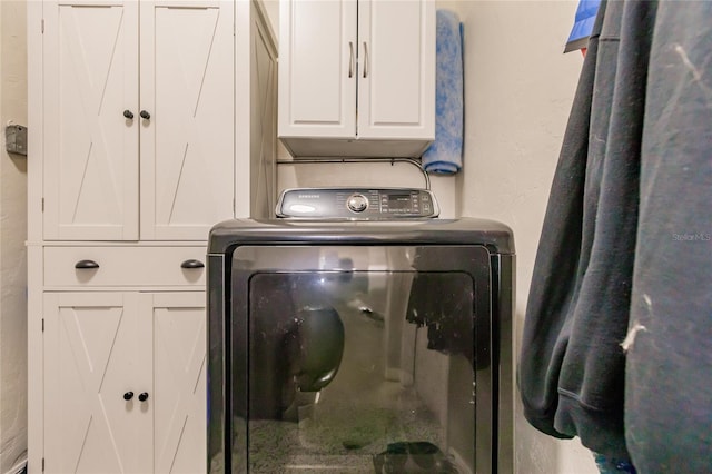 washroom with washer / dryer and cabinets