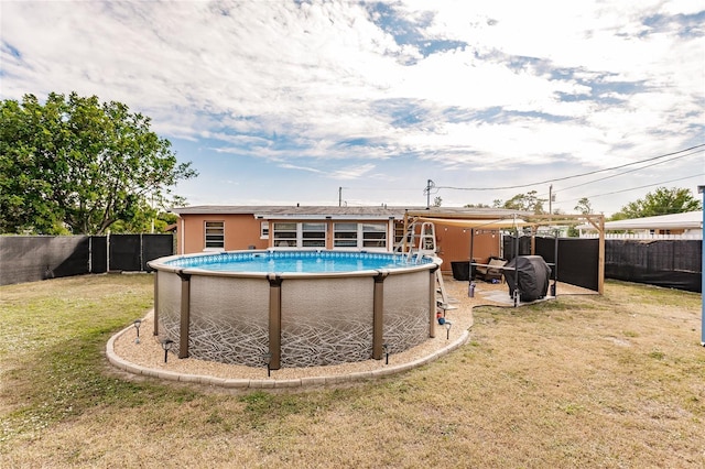 view of swimming pool with a lawn