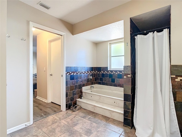 bathroom featuring tile walls, tile patterned flooring, and independent shower and bath