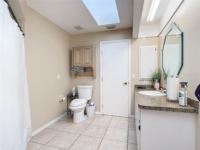 bathroom featuring vanity, toilet, tile patterned floors, and a skylight