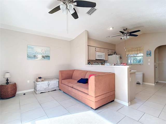 tiled living room with ceiling fan and lofted ceiling