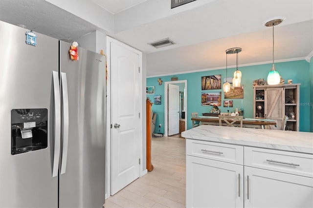 kitchen featuring stainless steel refrigerator with ice dispenser, ornamental molding, white cabinets, and hanging light fixtures