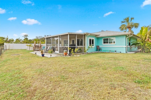 back of property with a patio area, a yard, and a sunroom