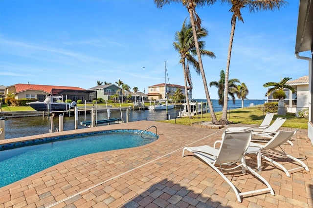 view of swimming pool with a water view, a boat dock, and a patio