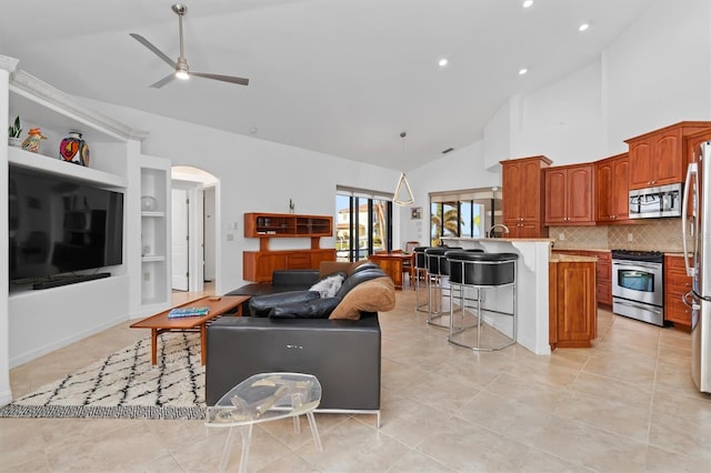 living room with ceiling fan, light tile patterned flooring, built in features, and high vaulted ceiling