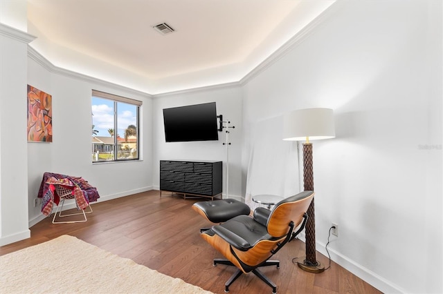 living area featuring crown molding and hardwood / wood-style floors