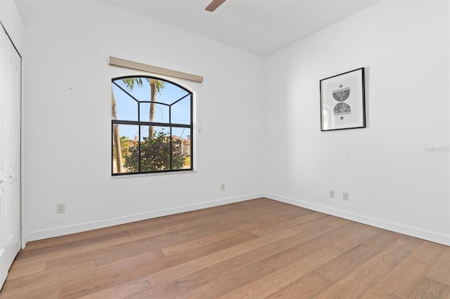 empty room with ceiling fan and light hardwood / wood-style flooring