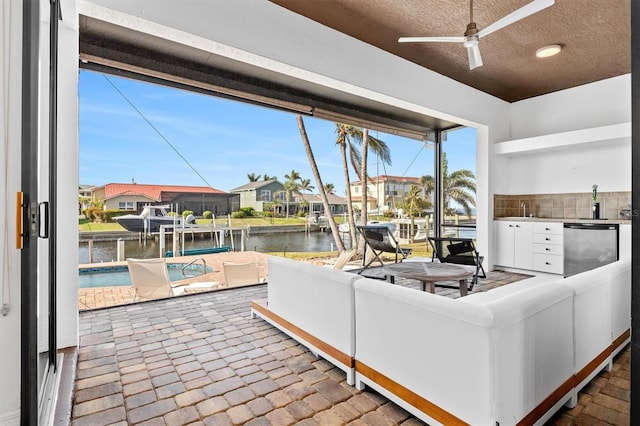 living room with ceiling fan and a water view