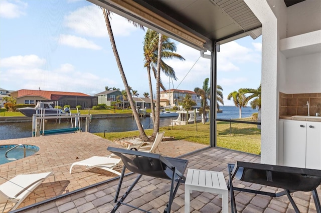 view of patio featuring a water view, a dock, and sink