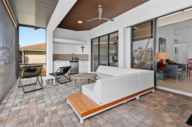 view of patio / terrace featuring ceiling fan, an outdoor living space, and sink