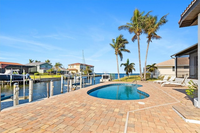 view of pool with a dock, a water view, and a patio