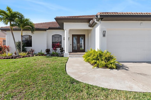 mediterranean / spanish home with a front yard, french doors, and a garage