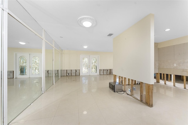 corridor with french doors and light tile patterned floors