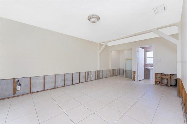 interior space featuring vaulted ceiling and light tile patterned floors