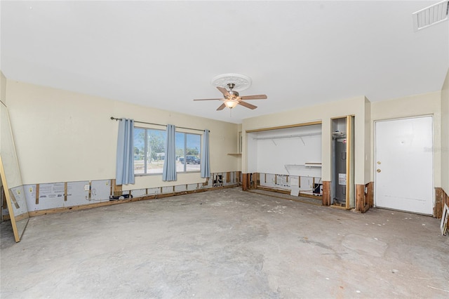 unfurnished living room with water heater and ceiling fan