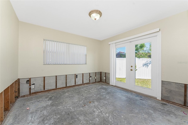 unfurnished room with french doors and concrete floors