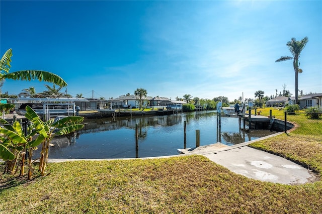 view of dock with a yard and a water view