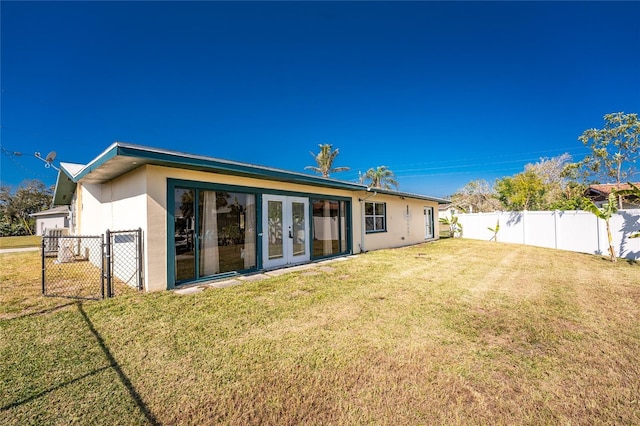 rear view of house featuring french doors and a yard