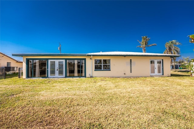 back of property featuring french doors and a yard